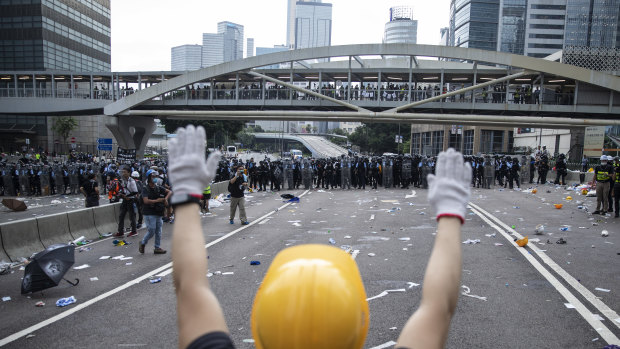 A protester raises his hands in front of riot police outside the Hong Kong Legislative Council on Wednesday.