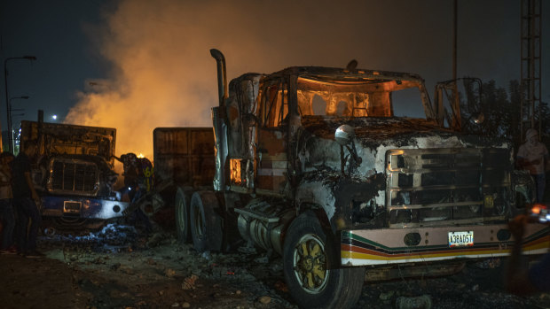 Burnt trucks previously loaded with humanitarian aid sit on the Francisco De Paula Santander International Bridge near the border with Venezuela in Cucuta, Colombia, on Saturday.