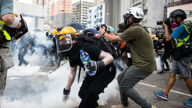 Demonstrators throw back tear gas canisters during a protest in the Yuen Long district.
