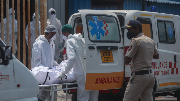 Health workers carry the body of a COVID-19 casualty outside a field hospital in Mumbai on May 4.