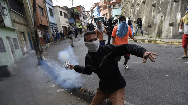 The protesters in Caracas were dispersed with tear gas as residents set fire to a barricade of trash and chanted demands that Maduro leave office.
