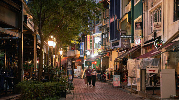 Hopes for a travel bubble with Australia: pedestrians walk along a deserted street in the Boat Quay area of Singapore.