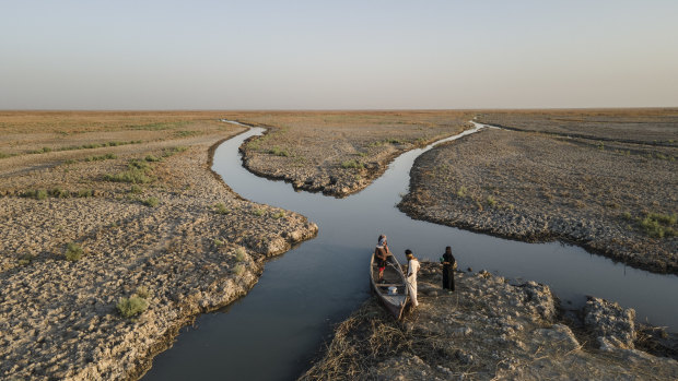 Residents prepare to travel into marshlands near Chibayish, Iraq. As water levels fall, the once verdant wetlands that formed a massive, shallow, reed-filled inland sea have been reduced to a thinning network of brackish canals. 
