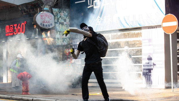 A demonstrator returns a tear gas canister towards riot police, who have become the focus of protests in Hong Kong.