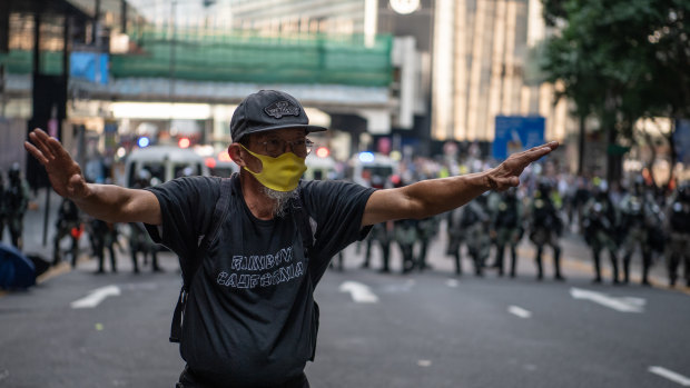 A man tells demonstrators to back away from a stand off against police line during a protest in the Central district of Hong Kong.