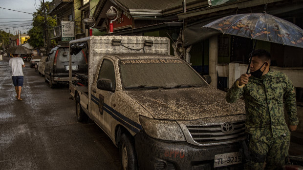 A police vehicle is covered in ash mixed with rainwater after the eruption.