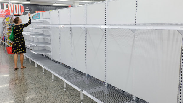 A customer walks past empty toilet paper shelves at a supermarket in Sydney on March 4, 2020. 