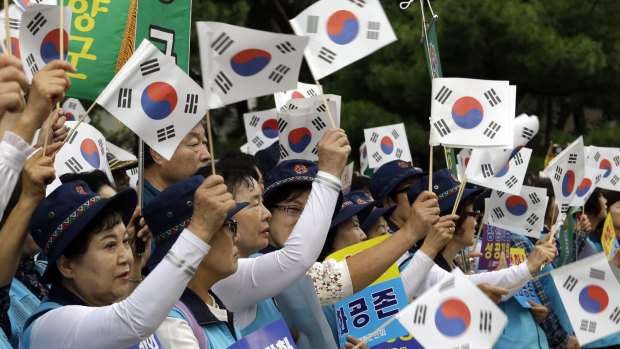 South Koreans wave their national flags during a rally to wish for the successful inter-Korean summit near the presidential Blue House in Seoul.