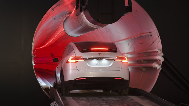 A modified Tesla Model X drives in the tunnel entrance before an unveiling event for the Boring Co.
