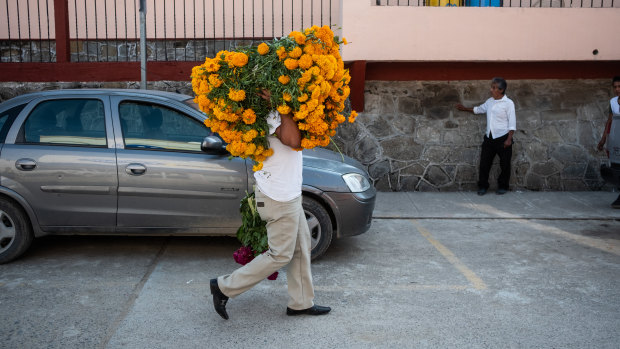 A person carries marigold flowers during Day of the Dead celebrations in Axtla de Terrazas, Mexico.