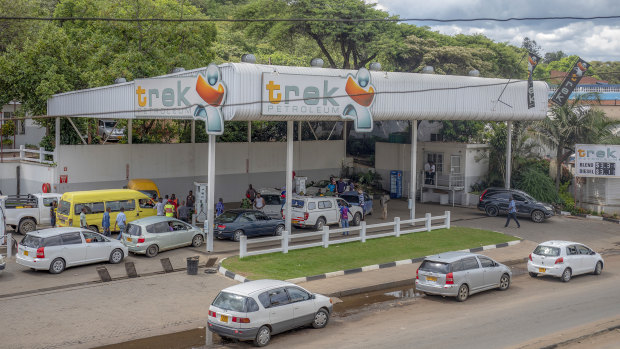 Customers queue at a petrol station in Harare. 