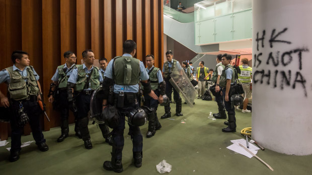 Riot police stand near graffiti inside the Legislative Council building after it was damaged by demonstrators.
