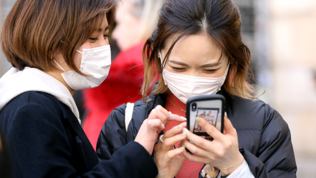 Tourists wearing face masks at the Trevi Fountain in Rome this week amid the spread of the virus in Italy.

