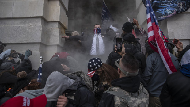 Demonstrators attempt to breach the US Capitol after they earlier stormed the building .