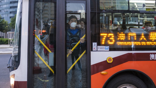 Passengers wearing protective masks ride a bus in Macau, China, in the early morning of Wednesday, February 5.