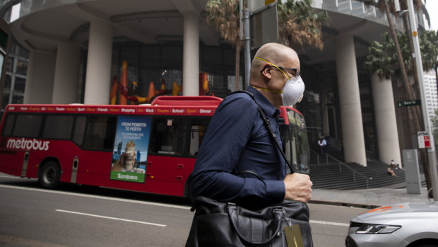 A commuter wearing a face mask in central Sydney, adapting to the new toxic norm.