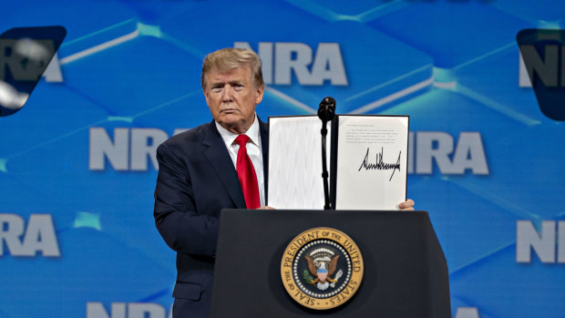 US President Donald Trump holds a signed letter asking the US Senate to stop the ratification process of the UN Arms Trade Treaty at the NRA's annual meeting in Indianapolis, in April.