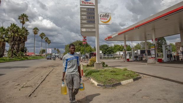 A pedestrian carries bottles containing fuel amid protests over fuel prices.