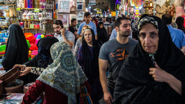 Visitors shop for goods at retail stores lining an arcade inside the Grand Bazaar in Tehran, Iran, last week.