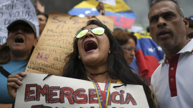 Demonstrators shout slogans during a protest on the sidelines of a visit by Michelle Bachelet in Caracas.