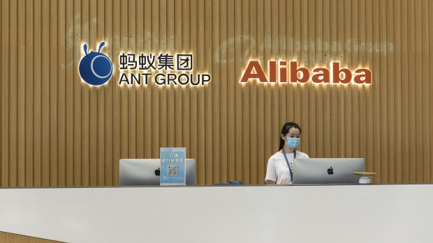 The Ant Group Co. logo and the Alibaba Group Holding Ltd. logo are displayed behind a reception desk at the company's headquarters in Hangzhou, China.