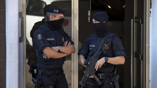 Police guard a building in Cornella after a man was shot dead at the police station.