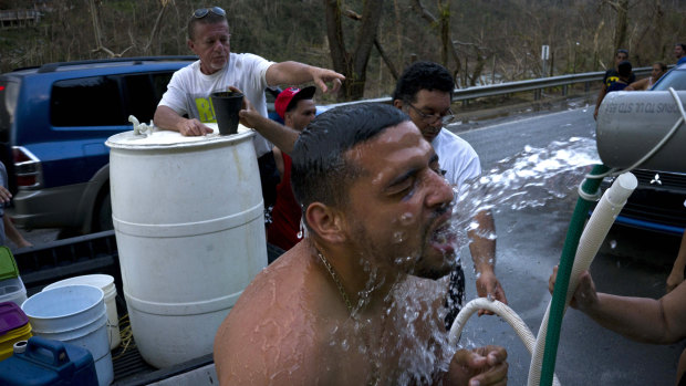 People bathe in water piped in from a mountain creek in Naranjito, Puerto Rico. Many of the deaths resulting from Hurricane Maria are believed to have been caused by infections spread by contaminated water.