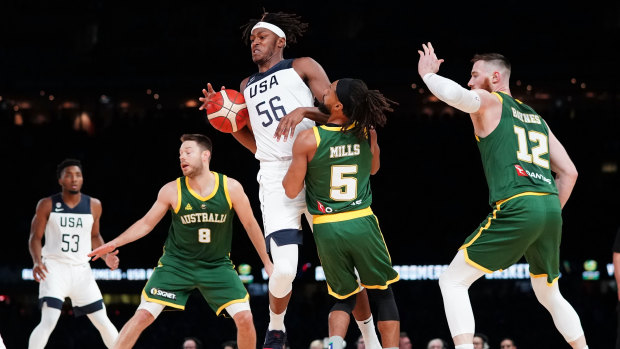Myles Turner of the USA and Patty Mills of Australia compete for the ball during the clash at Marvel stadium.