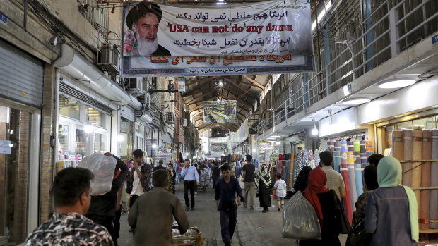 People walk at the old main bazaar in Tehran, where the effects of the sanctions can be easily felt.