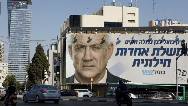 Pedestrians pass a billboard election poster for Benny Gantz, leader of the Blue and White party, in Tel Aviv. 