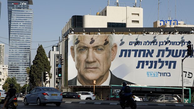 Pedestrians pass a billboard election poster for Benny Gantz, leader of the Blue and White party, in Tel Aviv. 