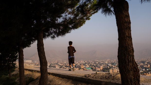 A boy runs along a wall at the top of Bibi Mahru Hill in Kabul, Afghanistan.