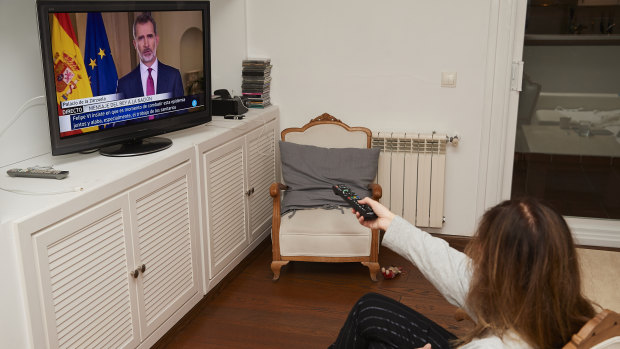 A woman watching King Felipe VI's speech at home in Madrid, Spain. 