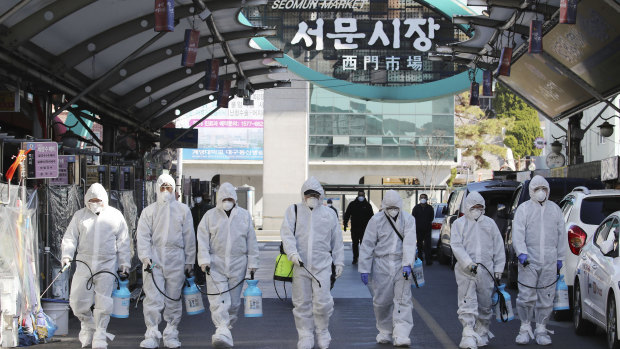 Workers spray disinfectant as a precaution against the COVID-19 at a local market in Daegu in South Korea.