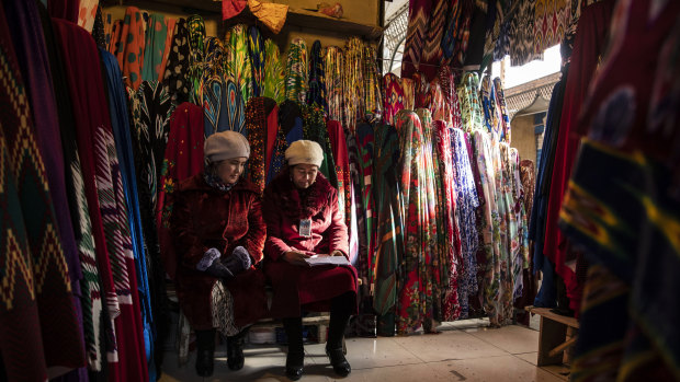 Vendors sit in a fabric stall inside the main bazaar.