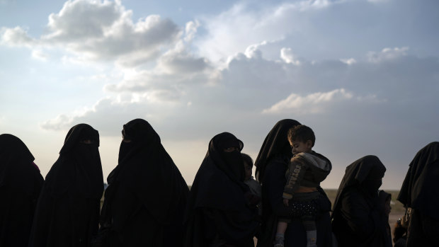 Women and children wait to be screened after being evacuated out of the last territory held by Islamic State militants, near Baghouz, eastern Syria.