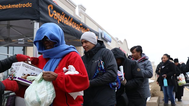 People receive food at a Capital Area Food Bank pop-stall for federal workers during the government shutdown in Washington, DC, on Saturday.