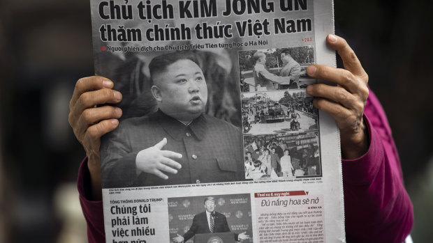 A woman reads a a newspaper featuring photographs of North Korean Leader Kim Jong-un, top, and US President Donald Trump, bottom, in Hanoi on Friday.