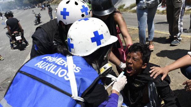 Medical personnel give first aid to a protester during a military uprising in Caracas, Venezuela. 