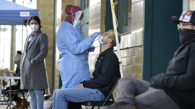 A medical staff member performs a Covid-19 test outside the Family Healthcare building in downtown Fargo, North Dakota.