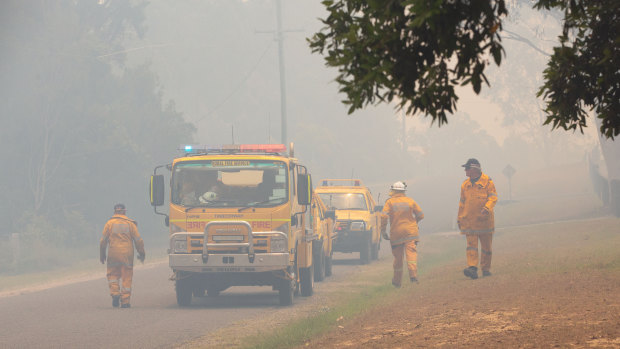 Firefighters are seen near fires at Lake Cooroibah Road and Jirrimah Crescent in Cooroibah on Saturday.