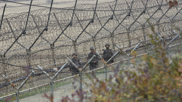 South Korean army soldiers patrol along the barbed-wire fence in Paju, South Korea.