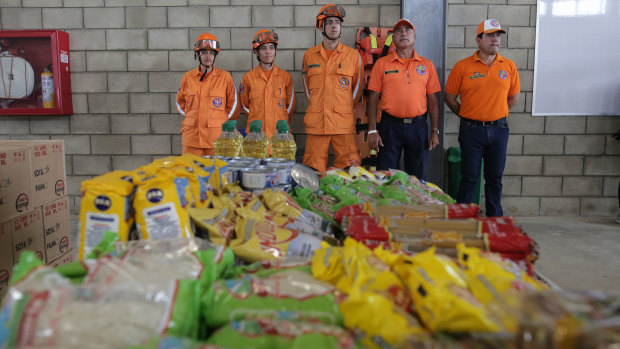 Colombian Civil Defence officers stand near a table of food from US humanitarian aid at the warehouse.