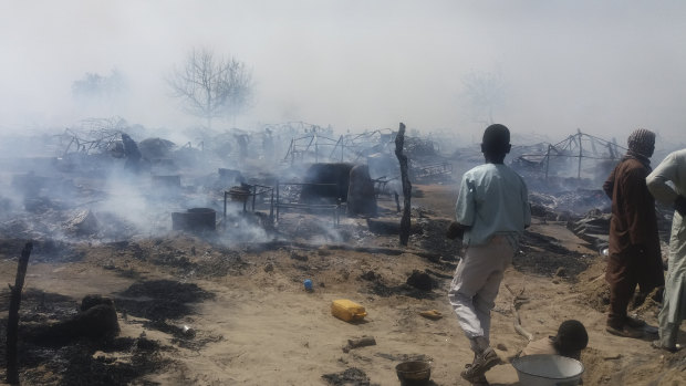 People check the remnants of houses destroyed by extremists in Monguno, Borno state, Nigeria, last year.