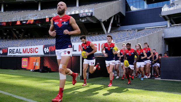 Leading man: Melbourne skipper Max Gawn runs out with his team at Optus Stadium in Perth on Sunday.