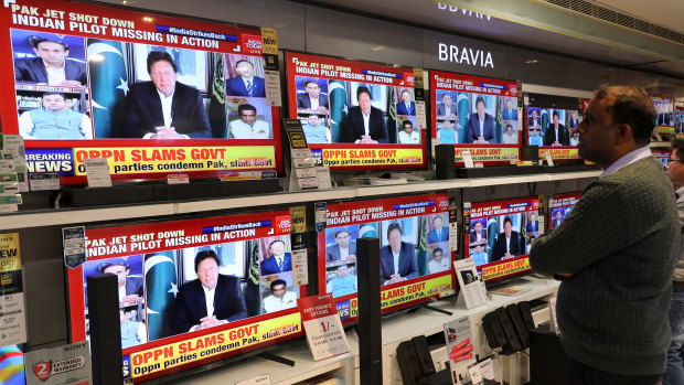 A man watches Imran Khan, Pakistan's president, give an address on a television screen in an electronics store in Delhi, India, on Wednesday.