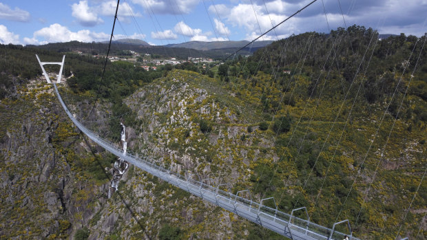 People walk across a narrow footbridge suspended across a river canyon, which claims to be the world’s longest pedestrian bridge, in Arouca, northern Portugal.