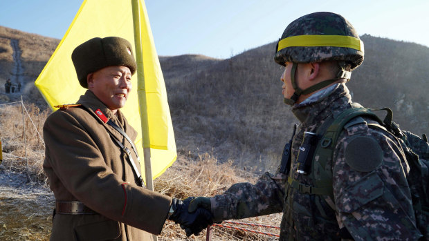 South Korean Army Colonel Yun Myung-shick, right, shakes hands with North Korean Lieutenant Colonel Ri Jong-su before crossing the DMZ line in 2018. They were verifying that each side's old guard posts had been removed.