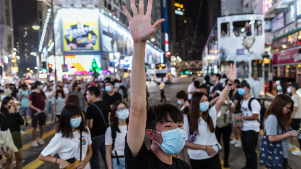 A demonstrator raises his hand as he blocks traffic on Hennessy Road during a protest in the Causeway Bay district of Hong Kong. 