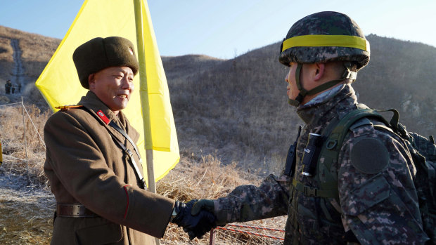 South Korean Army Colonel Yun Myung-shick, right, shakes hands with North Korean Lieutenant Colonel Ri Jong-su before crossing the DMZ line this week. They were verifying each side's  old guard posts have been removed.